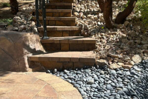Decorative Landscape Rock Installation Surrounding Stone Steps And Retaining Walls On A Sloped Las Vegas Property.