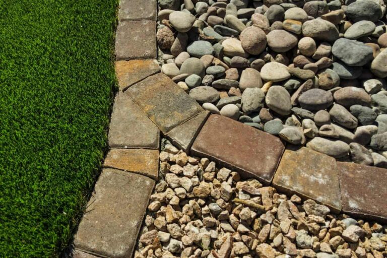 Close-Up Of Decorative Landscape Rock And Stone Edging Separating Artificial Grass From Desert Ground Cover In Las Vegas.