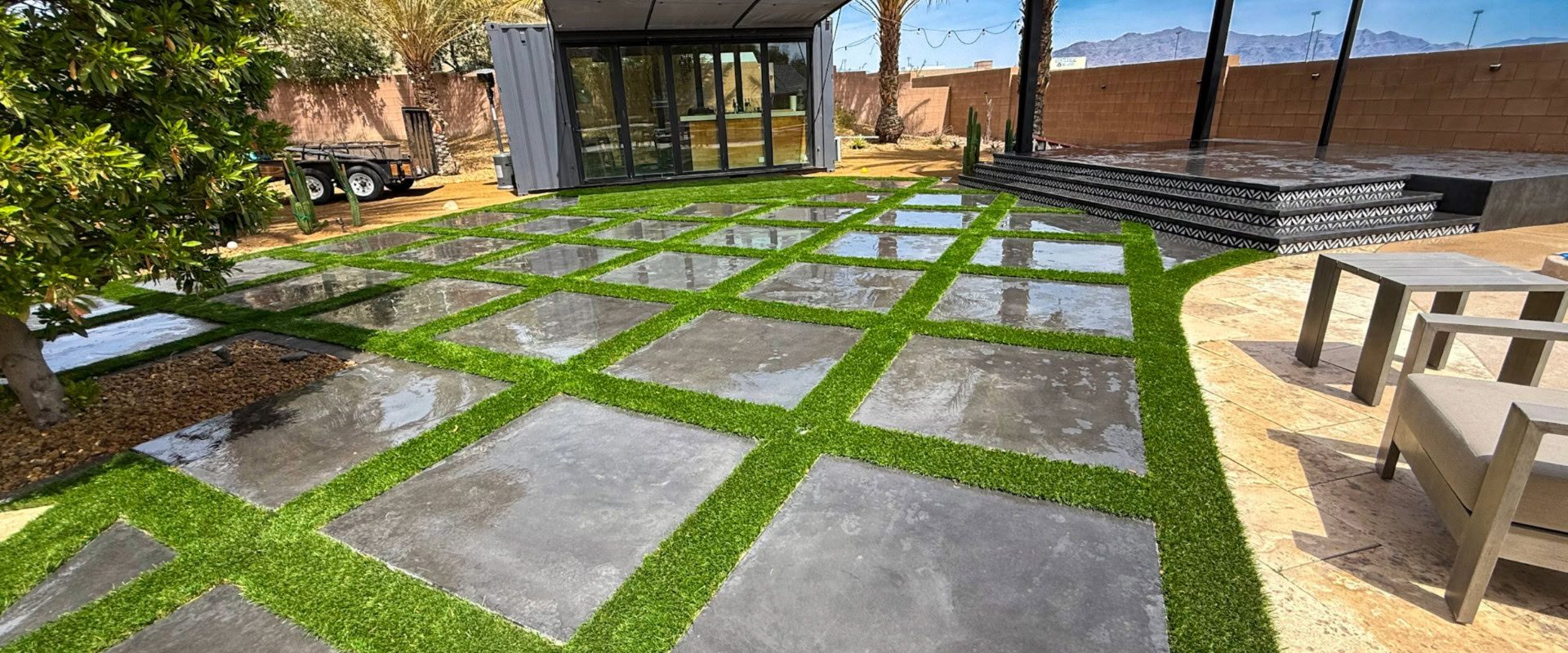 Close-Up Of Artificial Turf Installed By Green America Tree &Amp; Landscaping In Las Vegas, Showing Clean Edging Between Turf, Pavers, And Decorative Landscape Rock.